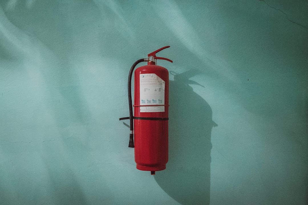 Fire extinguisher by Camping Checklist red fire extinguisher on green wall